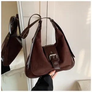 Detailansicht einer Vintage-Einkaufstasche aus Wildleder mit großer Metallschnalle in Dunkelbraun