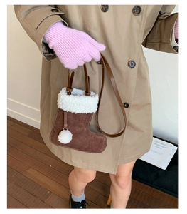 Creative Christmas boot-shaped suede crossbody bag with plush trim worn by a model