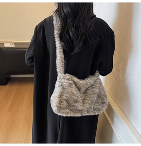 Detail of soft animal print faux fur tote bag with wide strap on a model wearing a black coat