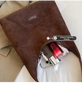 Macro shot showing large interior capacity of brown suede tote bag with daily essentials
