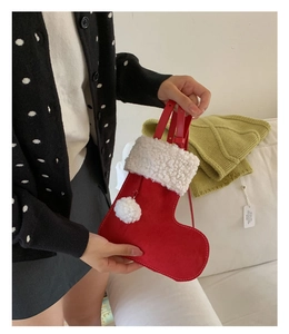 Detail of red suede Christmas stocking bag with white faux fur trim and leather strap