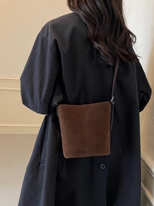 Brown frosted suede bucket bag with adjustable strap and embossed fashion text
