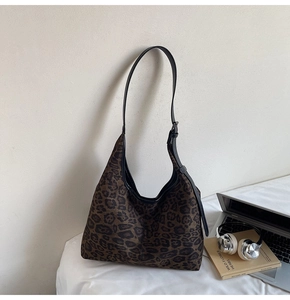 Detailed side view of the leopard print hobo tote bag with a black adjustable strap