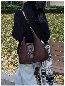 Detail der dunkelbraunen Vintage-Veloursledertasche mit Lederbesatz und Metallschnalle