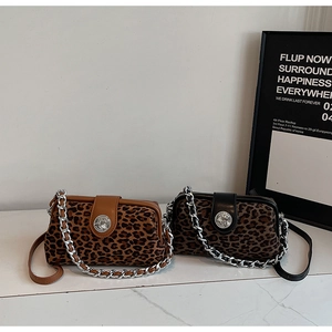 Detailed view of leopard print texture on handbag with metal chain and buckle