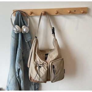 Dettaglio della borsa a tracolla in nylon kaki con multitasche e design con coulisse