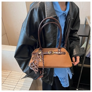 Close-up of brown matte suede handbag with dark leather strap and metal buckle details