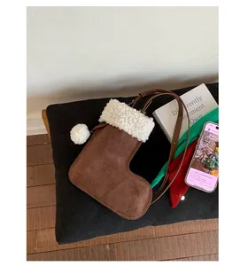 Mini suede Christmas stocking crossbody bag with fuzzy white trim and plush pom-poms