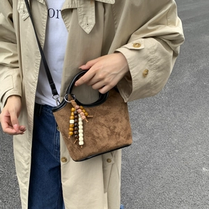 Sac seau marron en daim matelassé avec charm en perles colorées et bandoulière