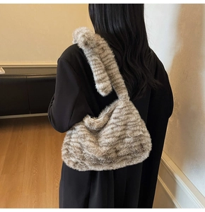 Detail of plush faux fur tote bag with striped texture and wide shoulder strap