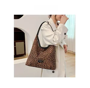 Close-up of leopard print shoulder bag with black leather straps and fashion label