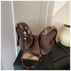 Detail of vintage brown leather tote bag with unique woven rope and glass bottle charm
