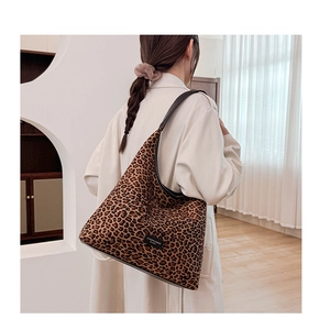 Detail shot of leopard print mini crossbody bag worn with a white coat over the shoulder
