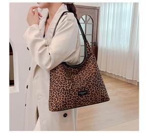 Close-up of leopard print mini bag with black leather strap on a beige winter coat