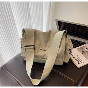 Detailed close-up of water-resistant nylon messenger bag with adjustable wide strap