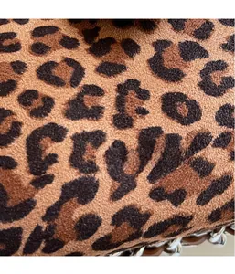 Macro detail of soft leopard print fabric and metallic silver chain on shoulder bag
