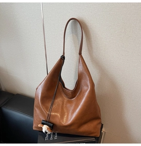 Detail of vintage brown tote bag with premium leather texture and plush puppy charm