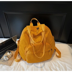 Detail of ginger yellow versatile tote backpack with side pockets and top handle