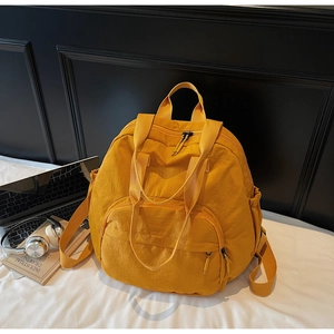 Close-up of mustard yellow nylon tote backpack with sturdy handles and wide main compartment