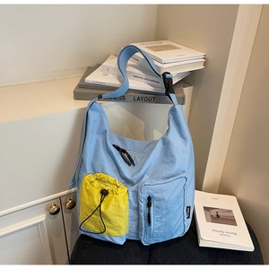 Dettaglio della borsa a tracolla in nylon azzurro con tasche multiple e cordino giallo