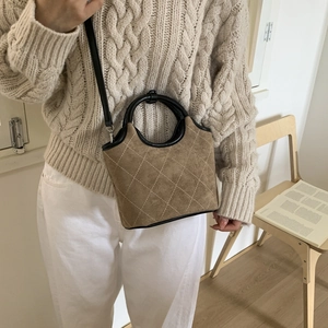 Sac seau en daim marron avec motif matelassé et poignée circulaire noire élégante