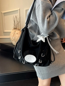 Black patent leather crescent bag with white patch detail and silver star pendant charm