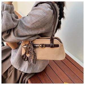 Detail of khaki frosted suede Boston bag with brown leather straps and metal hardware
