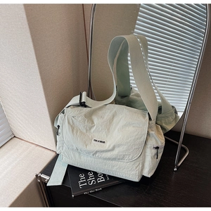 Close-up of mint green nylon tote bag with pleated texture and stylish shoulder strap