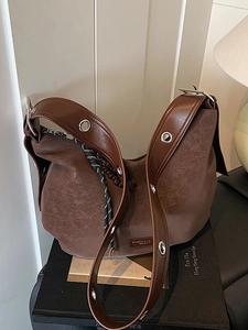 Vintage brown leather tote bag with wide shoulder strap and metal eyelet details