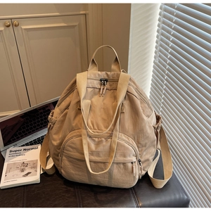 Lifestyle view of a khaki nylon tote backpack with multiple pockets in a home setting