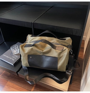 Olive green travel bag detail showing satin nylon texture and black leather accents