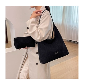 Detail view of black corduroy tote with matching zipper pouch and fashion logo tag