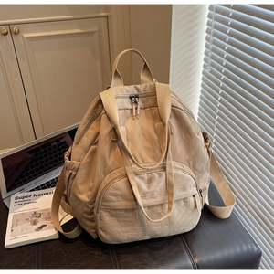 Macro detail of beige nylon tote backpack with reinforced straps and side pockets
