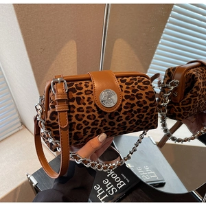 Detail of leopard print handbag with silver emblem and metallic chain strap on mirror