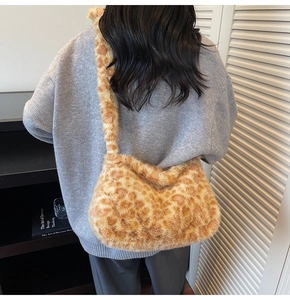 Detail of plush leopard print tote bag styled with a gray sweater for autumn vibes