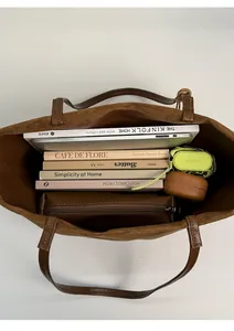 Vista dall'alto della borsa tote in pelle scamosciata marrone con libri e tablet