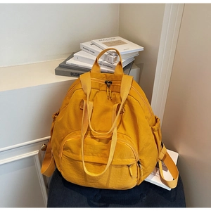 Close-up of bright yellow tote bag with front zipper pocket and side elastic compartments