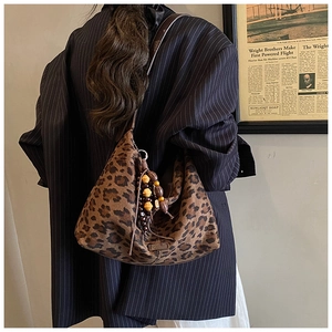Detailed macro view of vintage leopard print tote bag with decorative wooden beaded charm