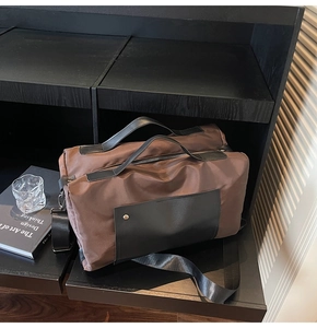 Detailed close-up of dark brown travel bag texture and black leather handle with metal buckle