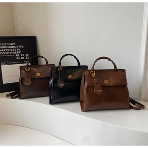 Detailed shot of retro matte leather backpacks in black and brown with metal twist locks