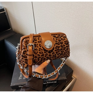 Macro detail of leopard print handbag featuring leather trim and silver metal hardware