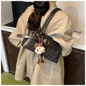 Vista posteriore della borsa a spalla vintage in pelle nera con fibbia oro e ciondolo a cucciolo