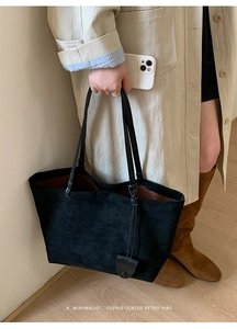 Dettaglio della borsa tote in pelle scamosciata nera opaca con manici sottili