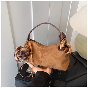Brown faux suede pillow bag with gold chain and leopard print pom-pom detail