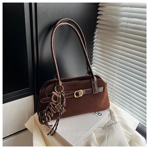 Detail view of coffee suede shoulder bag featuring gold buckle and small abacus charm