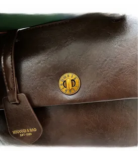 Close-up of brown lychee texture leather with vintage gold round metal twist lock