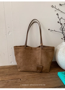 Dettaglio di una borsa tote vintage in pelle scamosciata marrone con manici fini