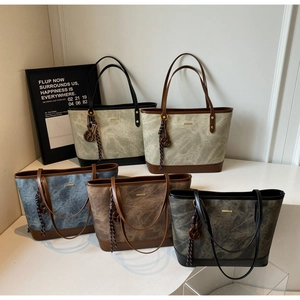 Detail of marble pattern tote bags with leather handles and gold metal accents