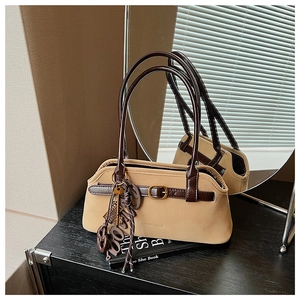 Detail of retro camel suede handbag with leather straps and metal buckle decoration