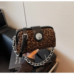 Detail of leopard print crossbody bag with silver chain and black leather flap closure